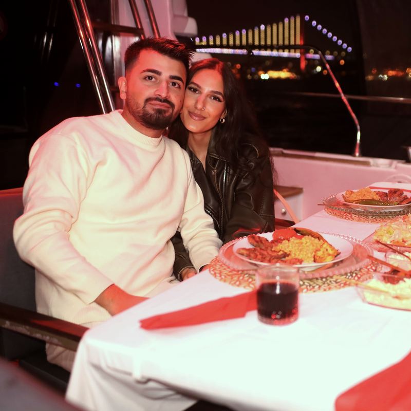 Couple at the table with the lit bridge in the background