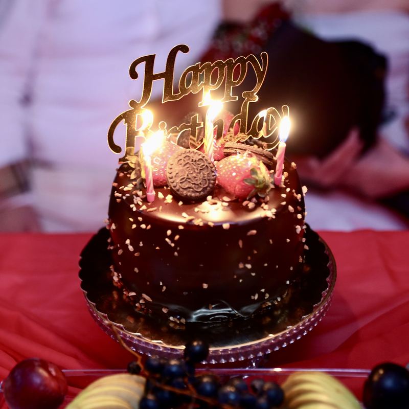 Chocolate cake with Happy Birthday topper and candles