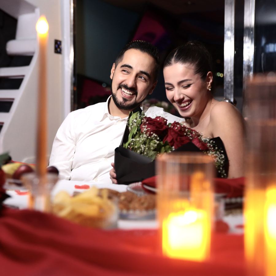 Couple celebrating a birthday by candlelight on board