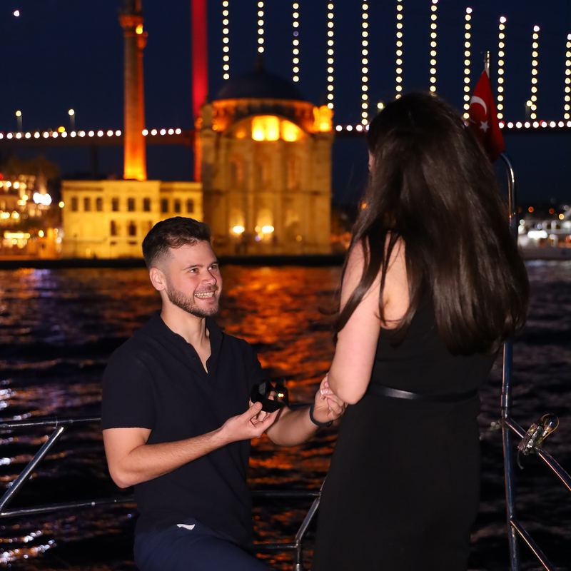 Proposal on one knee on deck with the lit Ortaköy Mosque behind
