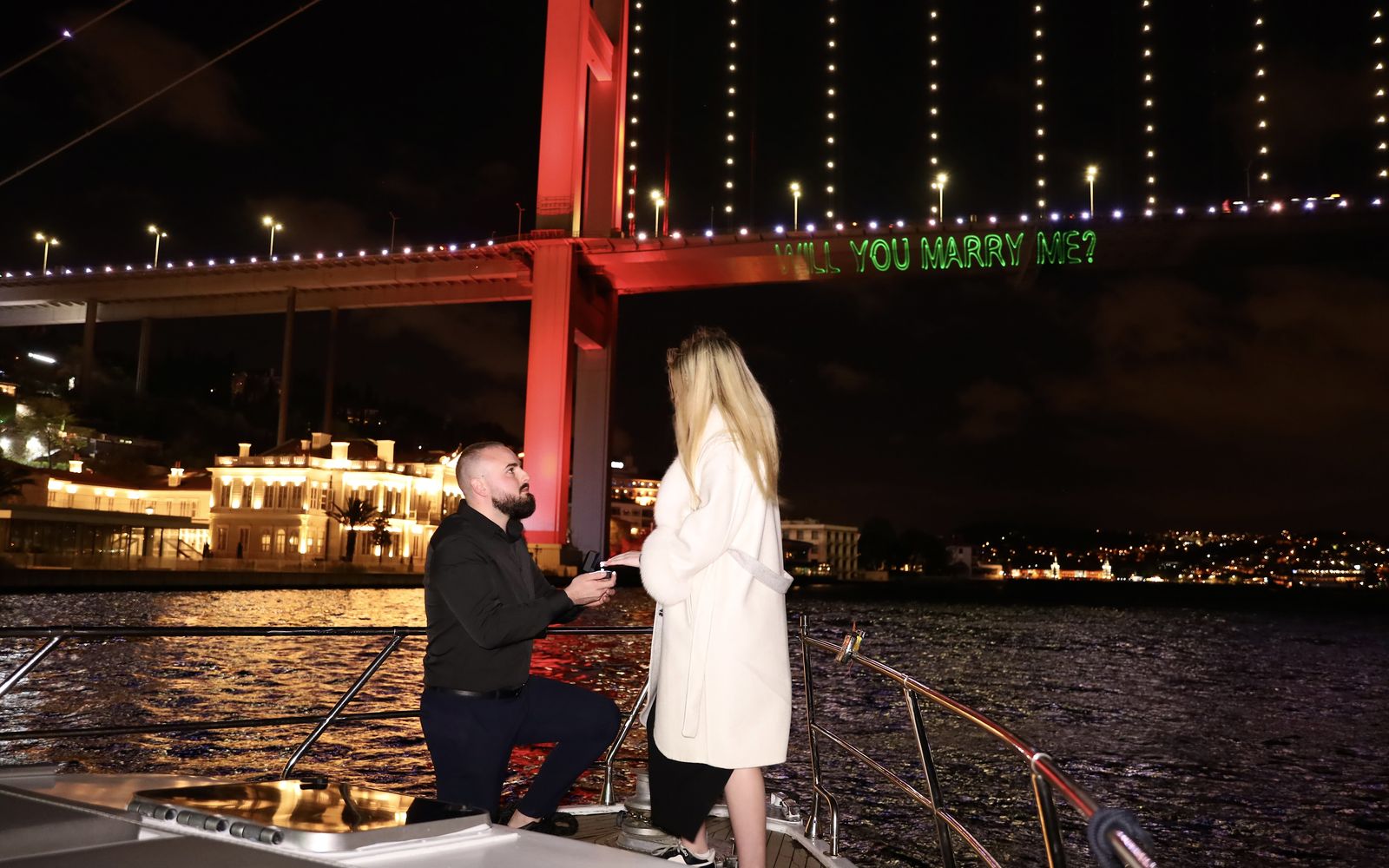 Proposal on the yacht under the Bosphorus Bridge, with the laser message “Will you marry me?” on the bridge