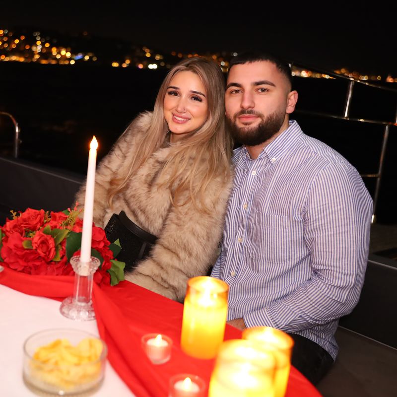 Couple at the table with candles and a bouquet of roses